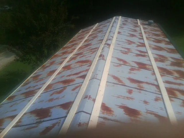Rusted metal roof panels with new wood purlins before replacement — Storm Damage Roof Repair in Timnath by Roofing Brothers